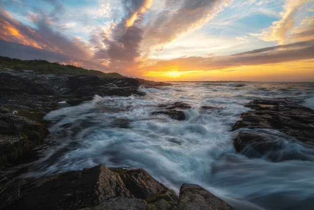 Sunset over the rocky shore at Beavertail State Park, Jamestown
