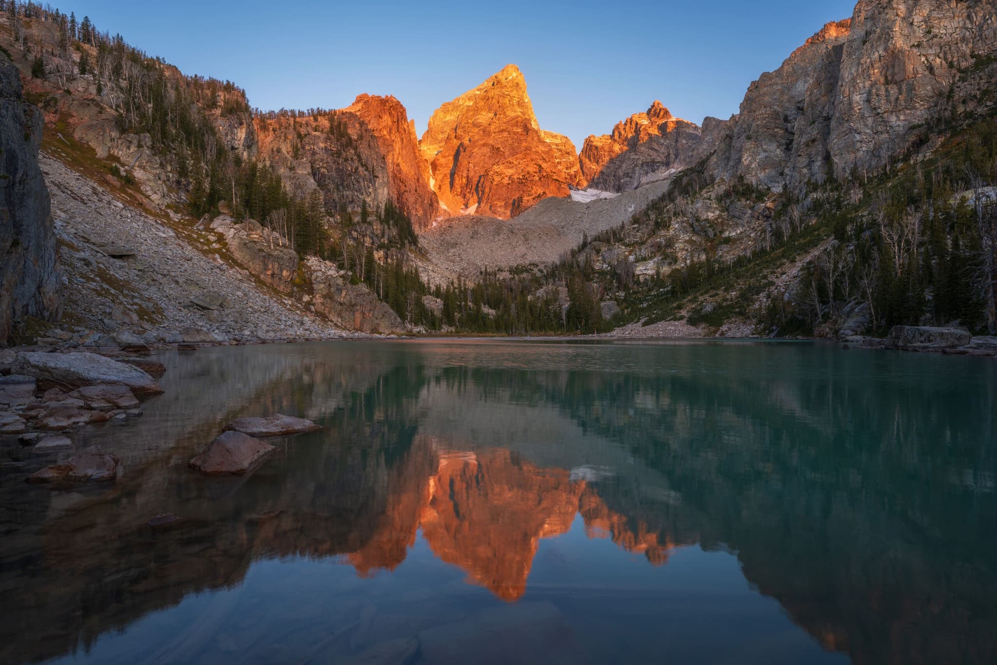 Alpenglow on the peaks above Delta Lake, reflected in still water